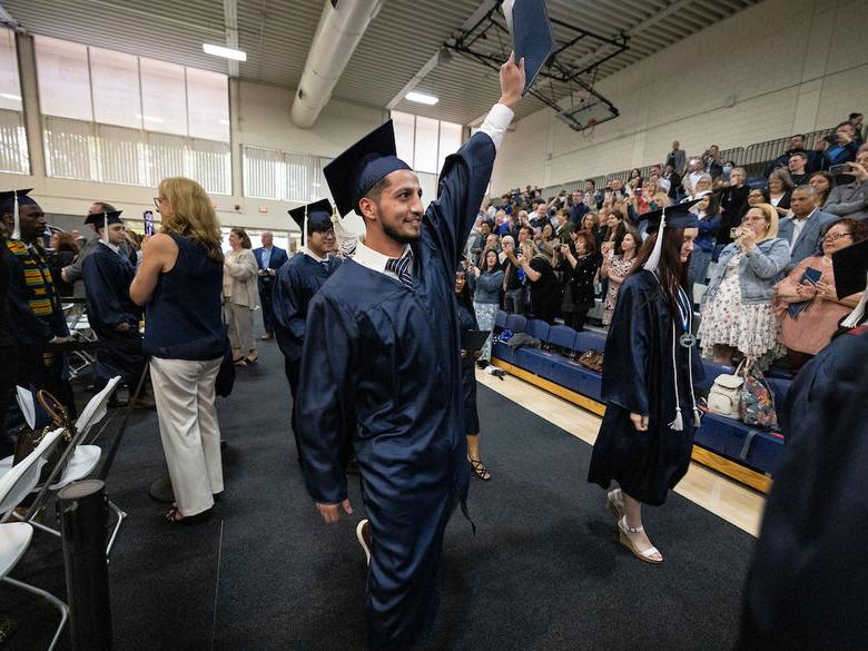 Student at graduation waving